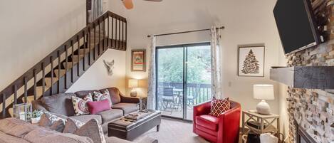 Living room with gas fireplace and staircase leading to loft/2 sleeping areas.