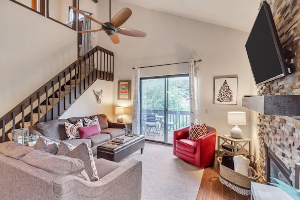 Living room with gas fireplace and staircase leading to loft/2 sleeping areas.