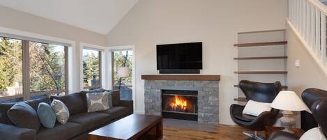Living room features hardwood floors, a presto log fireplace, and a TV