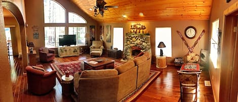 Large living room with vaulted ceiling open to dining room and kitchen