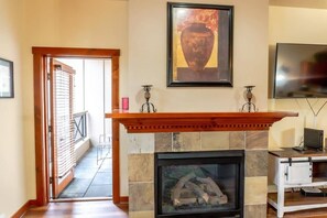 The beautiful gas fireplace is nestled between the flat-screen TV and door to the private patio, where you will find a table and chairs for two.