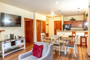 The view from the living room highlights the ideal, open-concept layout of this home. Here you can see the flat-screen TV as well as the dining and kitchen areas.