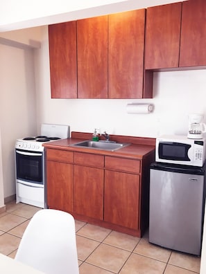 Cocina equipada con los utensilios básicos, tostadora, estufa, cafetera y otros.