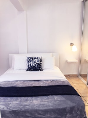 Dormitorio con cama Queen en el que puede acomodar a 2 personas, tiene AC.