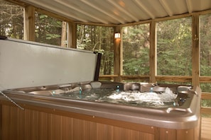 Relaxing hot tub in a beautiful setting in a screened in porch.