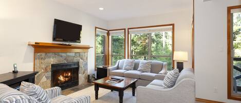 Living room with fireplace, TV, and scenic views