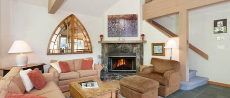 Living room that features comfy couches, a cozy presto log fireplace, cable TV, and a stereo