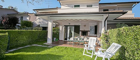 La casa con jardín y terraza cubierta.