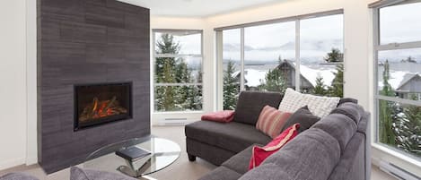 Spacious and bright living area with fireplace, mountain views and TV