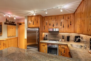 Kitchen features contemporary stainless steel appliances and granite counters