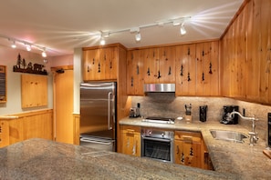 Kitchen features contemporary stainless steel appliances and granite counters