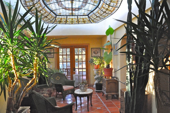 Solarium features 19th c. stained glass ceiling, french doors to porch