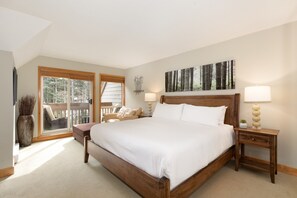 Primary bedroom with king bed, sitting area, and private balcony