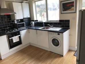 Kitchen with cooker, oven, microwave, fridge, kettle, toaster.