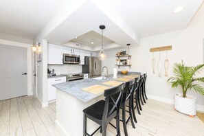 Kitchen has bar seating for five and a fully stocked kitchen.