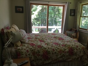 Master bedroom with TV, access to deck and view of lake.