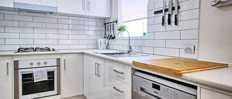 modern kitchen with dishwasher, washing machine, oven/stove