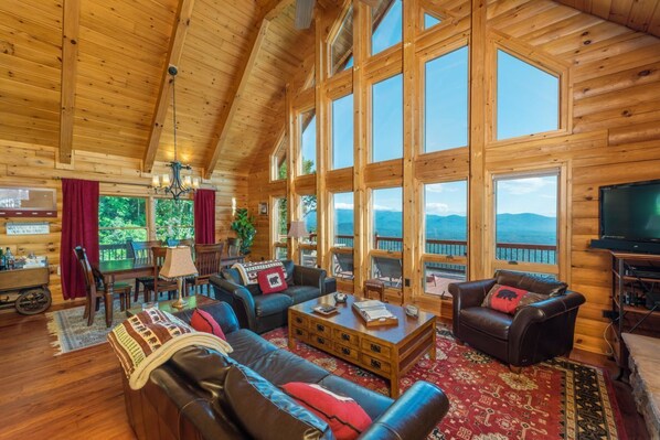 Open concept living & dining room with floor-to-ceiling windows offering up stunning mountain views.