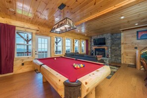 Lower level game room and den with pool table, gas logs fireplace, and satellite TV.