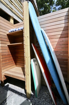 surf board storage next to outdoor shower