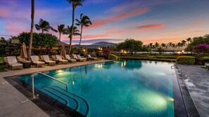 Infinity pool surrounded by cushioned lounge chairs