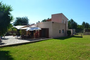 Außenansicht Küchenseite mit Eßtisch, Terrasse und Garten 