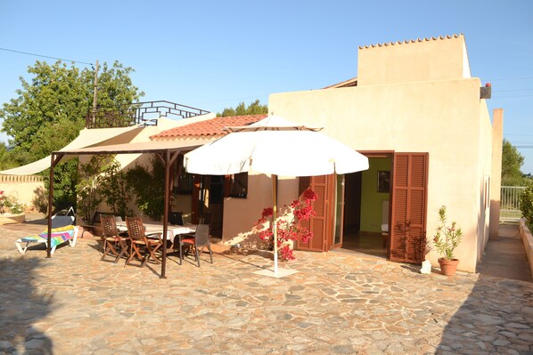 überdachte Terrasse mit Eßtisch und Schlafzimmer No.2