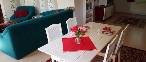 Wohnzimmer mit Couch, Esstisch und offener Küche