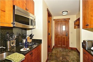 Entry area and resort kitchen. Doorway to left is bathroom.