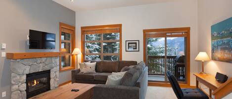 Lounge with fireplace, TV, and mountain views