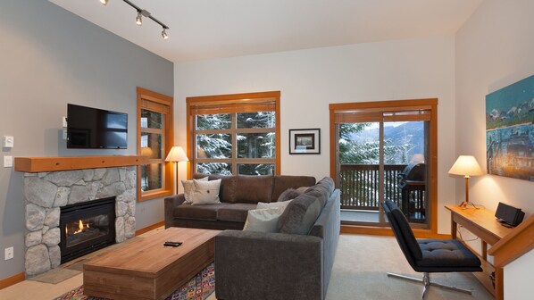 Lounge with fireplace, TV, and mountain views