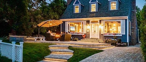 Fantasy Patio with lights, umbrella shade, rocking furniture, fire pit and BBQ.