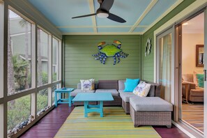 Large screened-in porch with multiple seating options for relaxation and gathering.