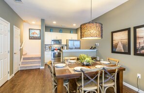 Dining room integrated with kitchen, with earth-toned furniture.