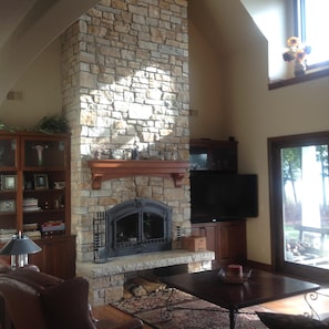 Relaxing great room with 2 story fireplace and huge windows to view water