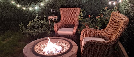 Lounge area by fire pit amongst the string lights