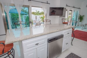 Fully equipped kitchen with bar stools. Cocina equipada con banquitos en barra.