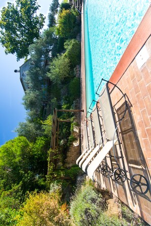 Private pool (14 metres x 7 metres) and pool loungers below the house