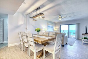 Elegant dining area with a modern chandelier, natural light, and an open-concept layout.