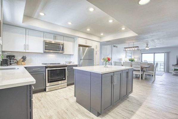 Spacious kitchen with sleek cabinetry, stainless steel appliances, and a large island.