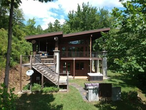 private side of cabin with fire pit and hot tub