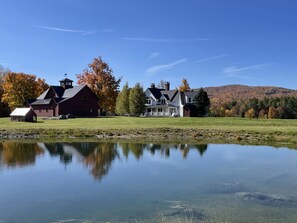 Pond view of house and barn
