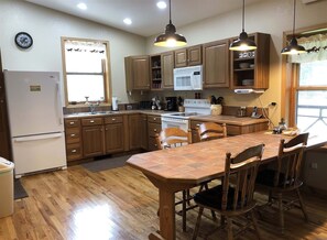 Kitchen and dining area with additional chairs and a small folding table in the mud room