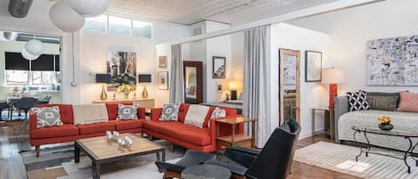 Just inside the entrance of  33 Carolina Lane Loft's main living area with 60" wall mounted tv, adjacent to the second king bed, separated by custom drapes for privacy. Other king bed is in a separate bedroom, just off the dining area. 