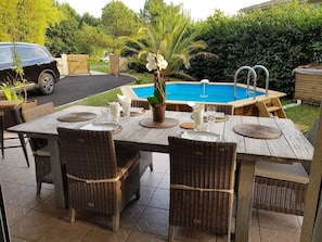 terrasse carrelée avec salle à manger extérieure et bar  