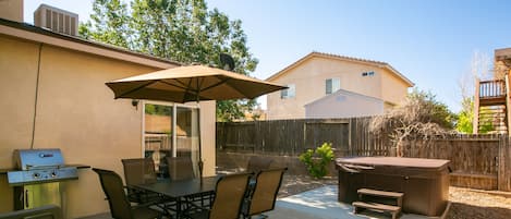 Patio seating for 6 and 4 extra chairs along with gas BBQ grill and hot tub!