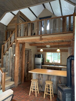 view from front door, kitchen with bathroom to the left of kitchen, loft above