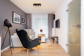 Another angle of the living room, showing the open floor plan leading towards the dining area. The layout is open and spacious.
