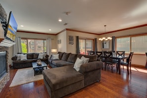 Living area with comfy sectional sofa, flat screen tv, fireplace, and shuffleboard