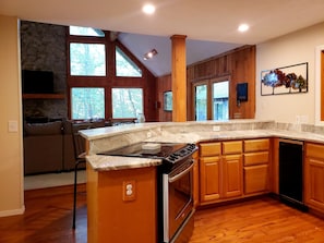 The granite bar ties the den and kitchen together. Plenty of natural light.